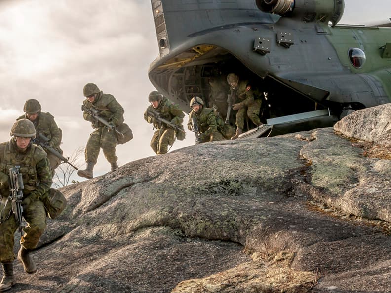 Canadian soldiers disembark from their attack helicopter in single file. Equipped with weapons and combat gear, they are determined, focussed and ready for the many adventures awaiting them in foreign territory.